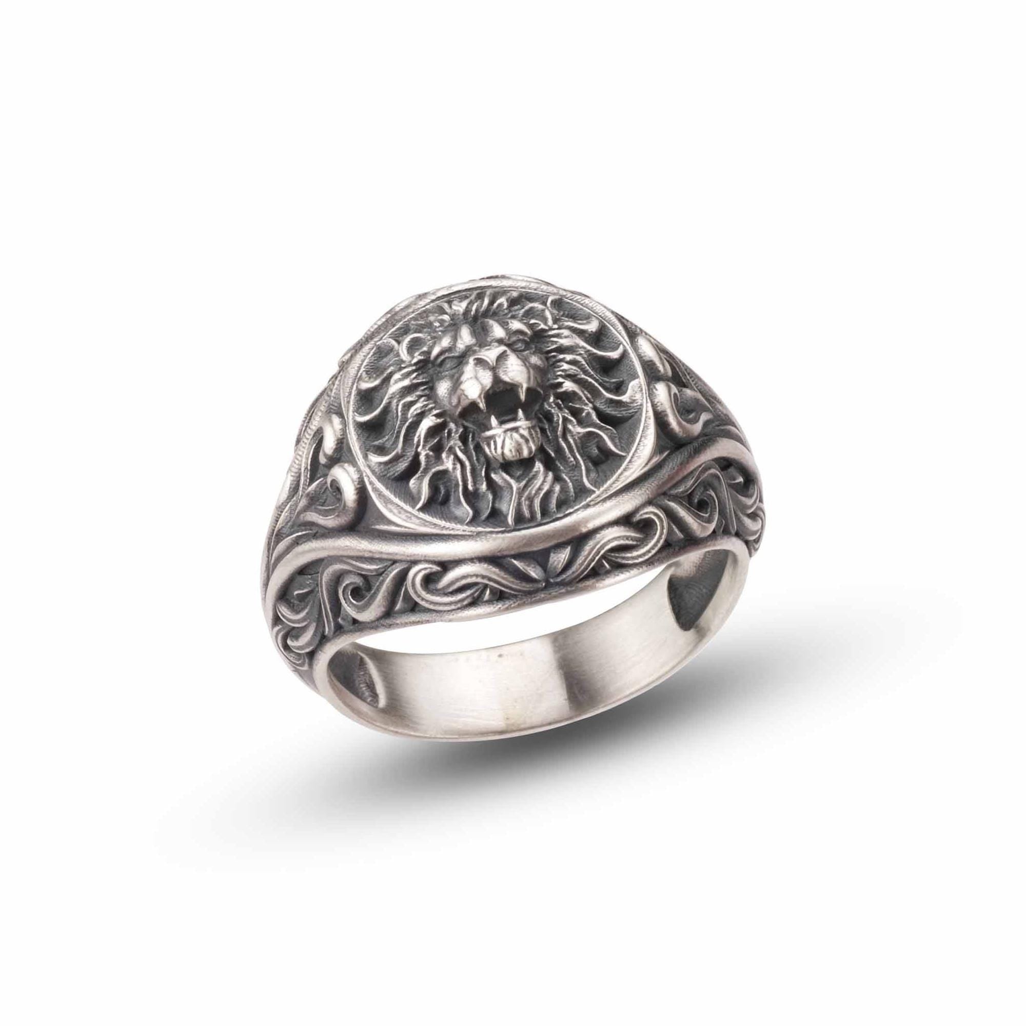 A silver ring with an intricate design featuring a lion's head.
