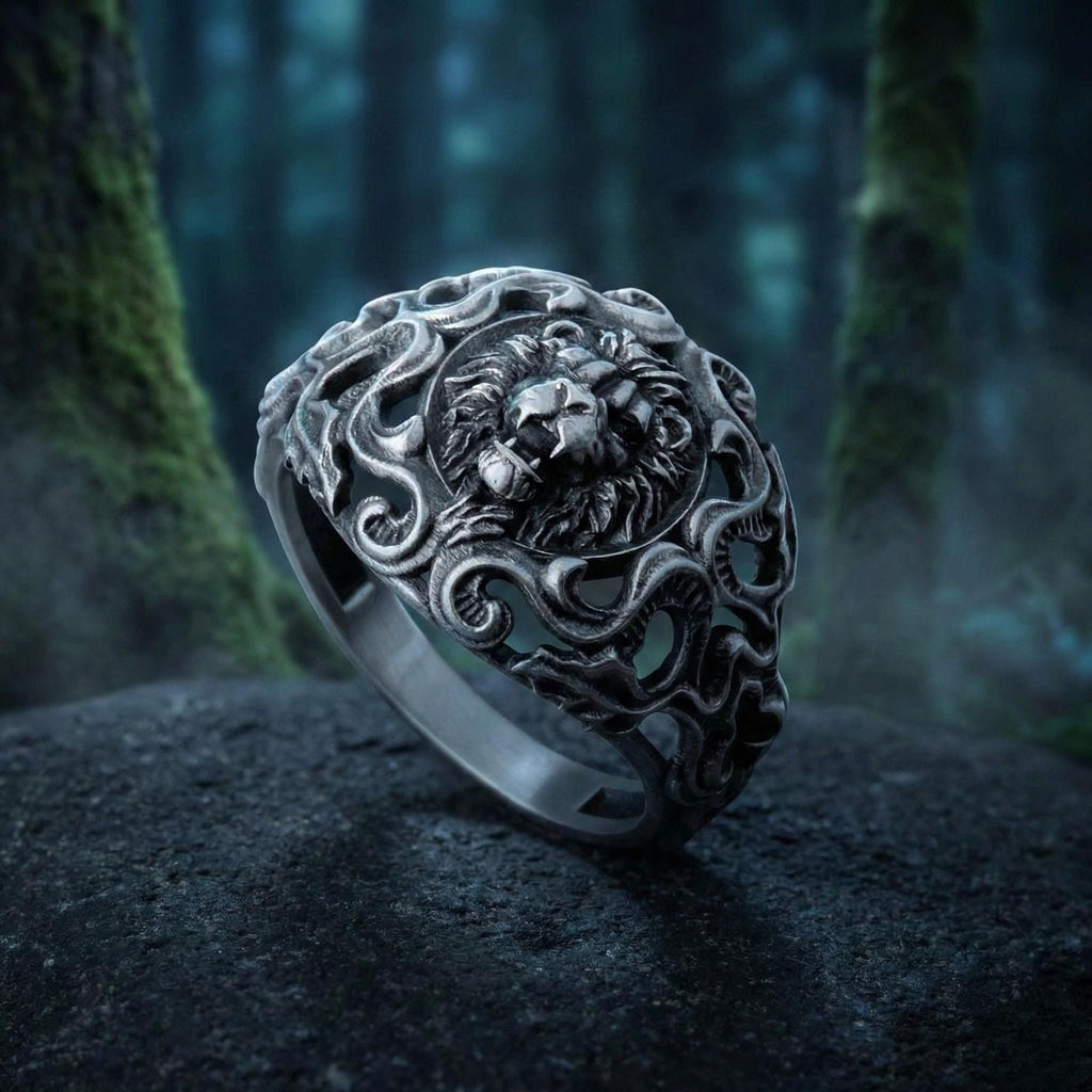 A silver ring with an intricate design featuring a lion's head, set against a dark, mossy background.