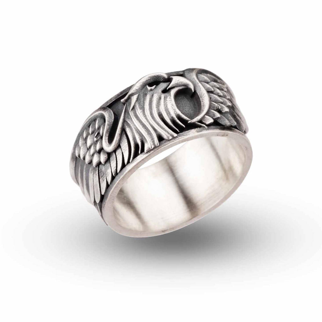 A silver ring with an intricate design featuring a stylized bird or eagle head.