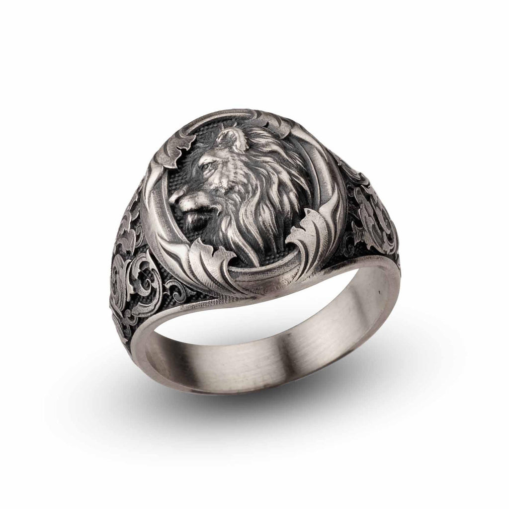 A silver ring with an intricate design featuring a lion's head.