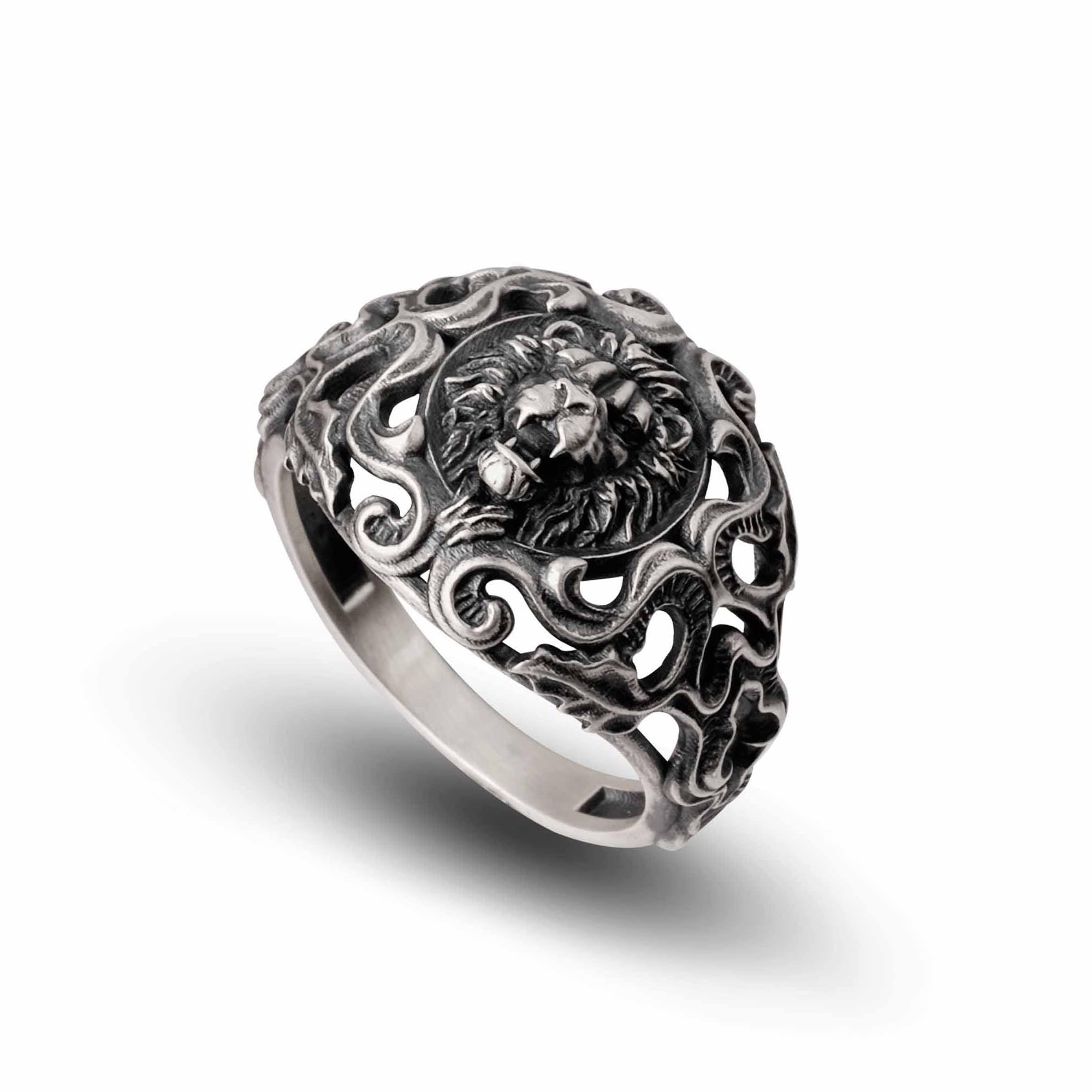 A silver ring with an intricate design featuring a lion's head at the center.