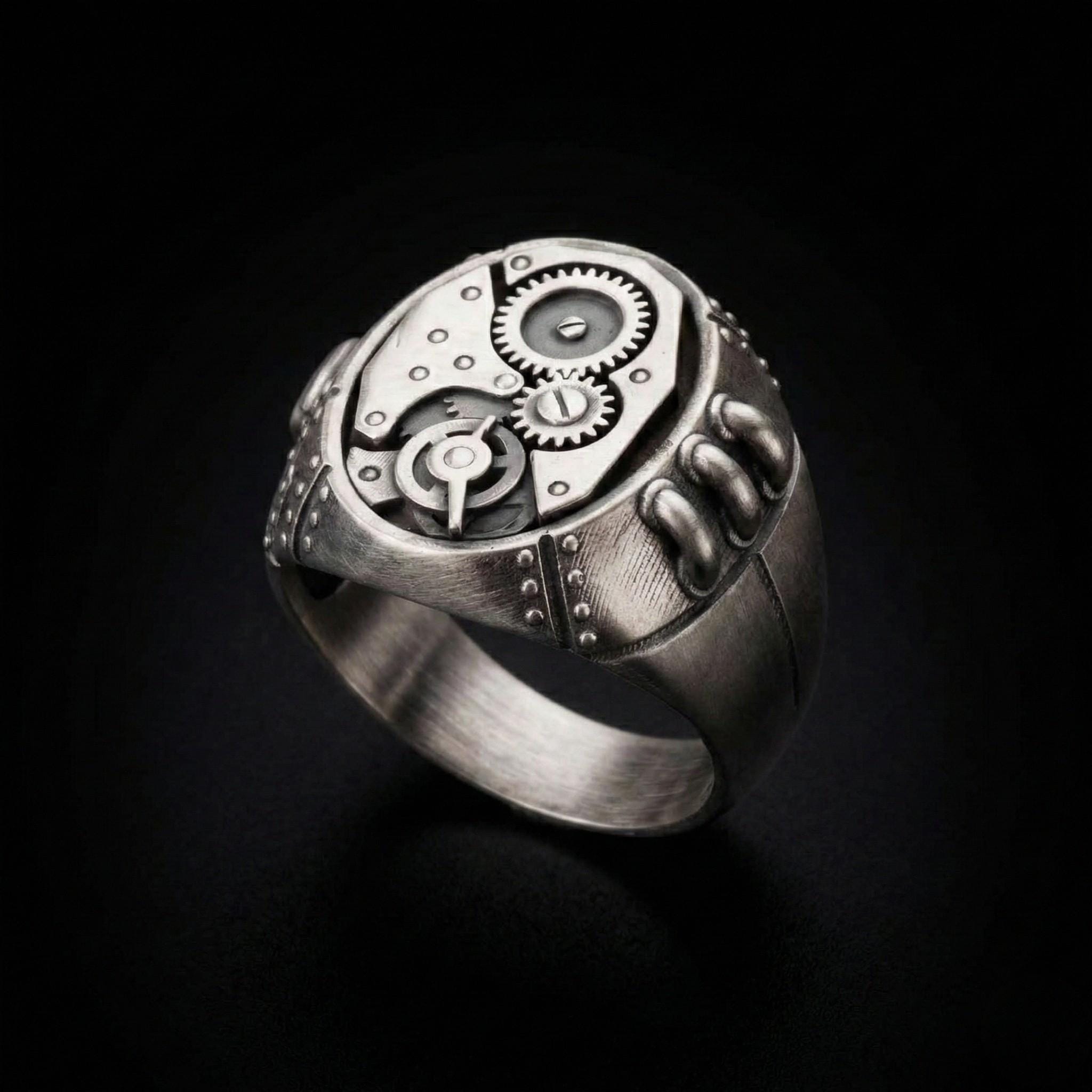 A silver ring with a complex mechanical design, featuring gears and other intricate details.