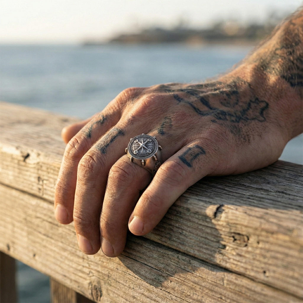 A close-up of a person's hand resting on a wooden railing, with a watch ring visible on one of the fingers.