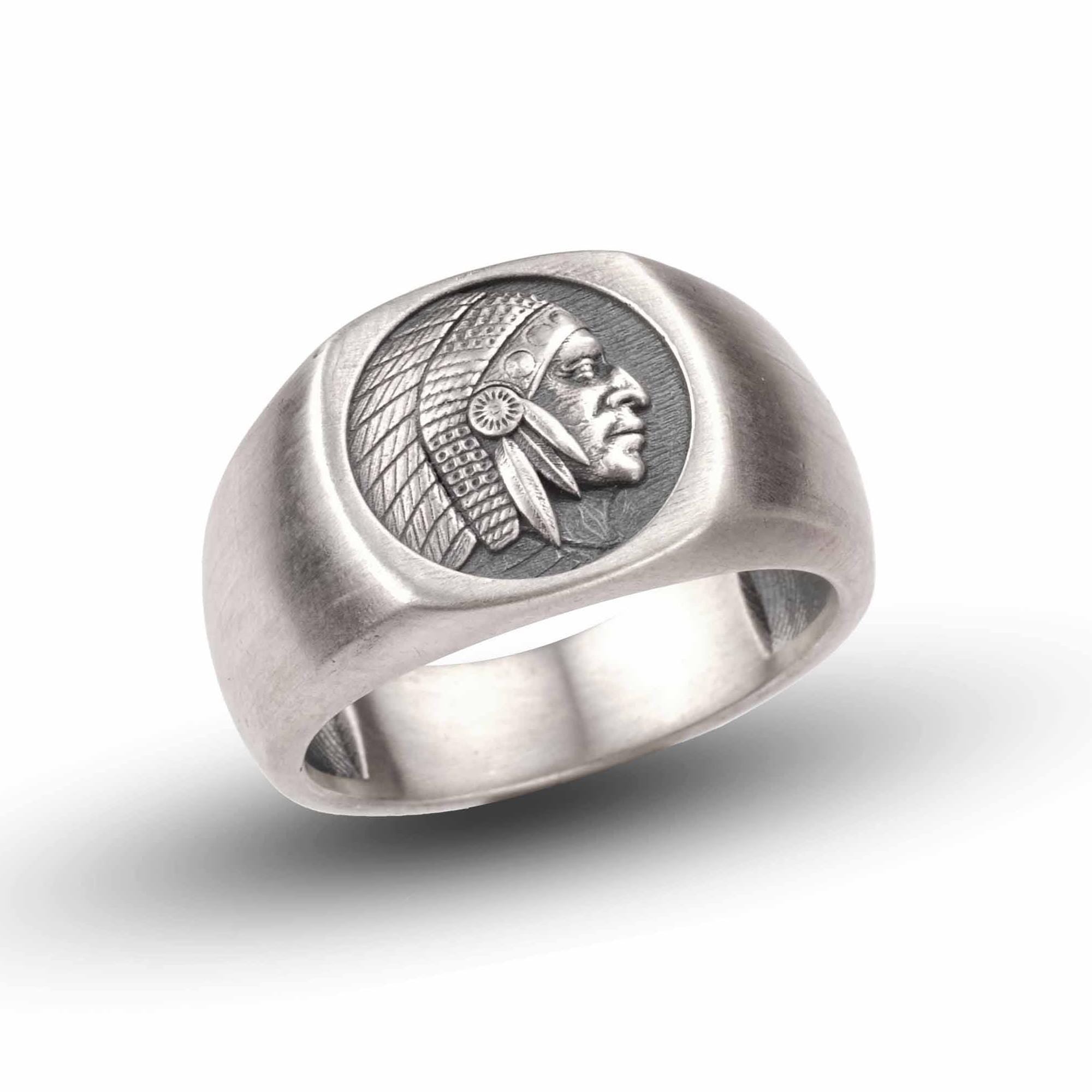 A silver ring with a carved profile of a Native American head on the band.