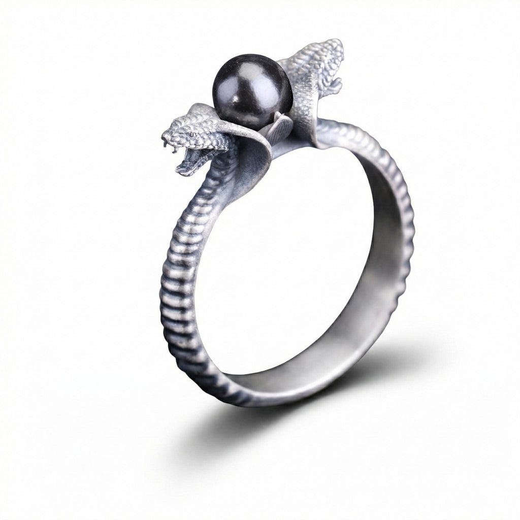 A silver ring with a large black gemstone, resembling a snake or cobra, on top of it.