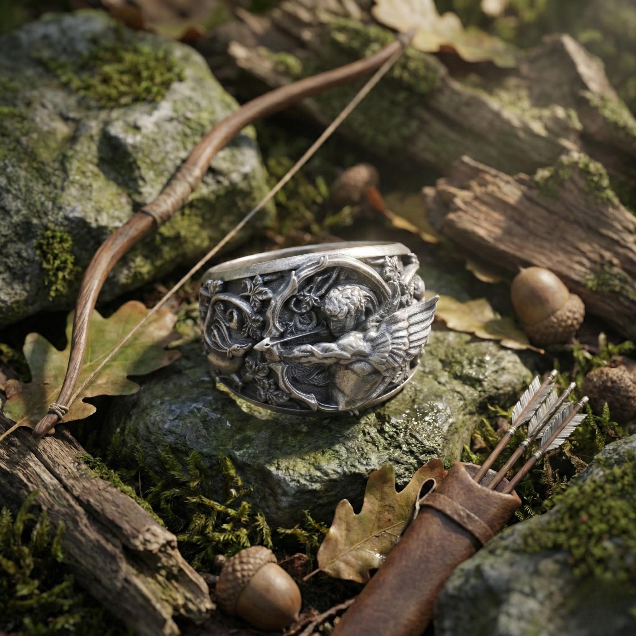 a ring with a detailed design, surrounded by various natural elements such as a bow and arrow, acorns, and moss.