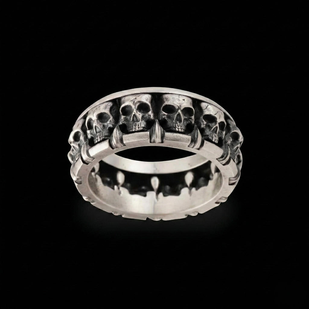 A silver ring with a row of skull designs on it, set against a black background.