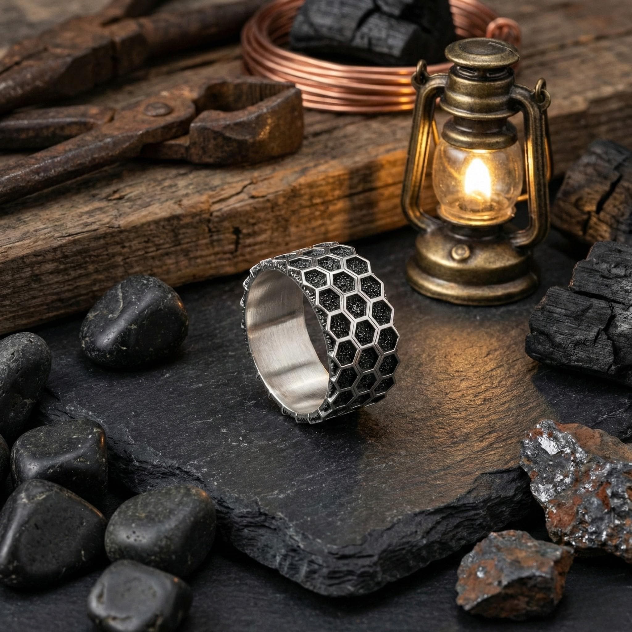 a ring with a hexagonal pattern, a lantern, and various minerals and tools arranged on a dark surface.