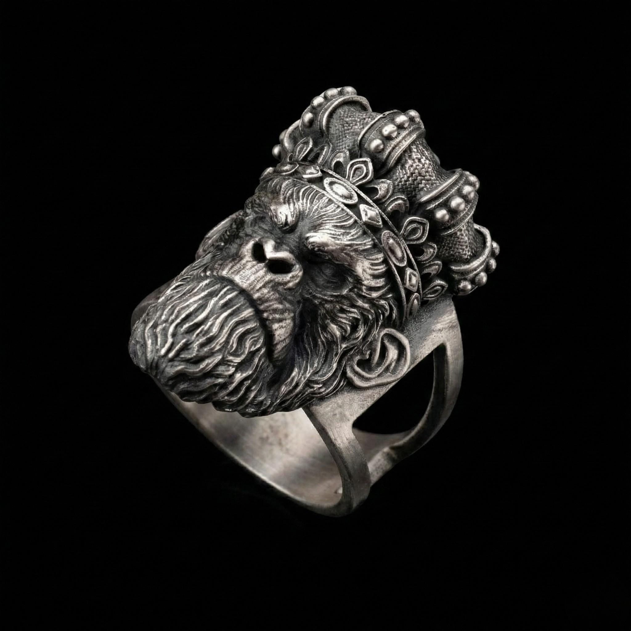 A silver ring featuring a detailed, engraved monkey head wearing a crown.