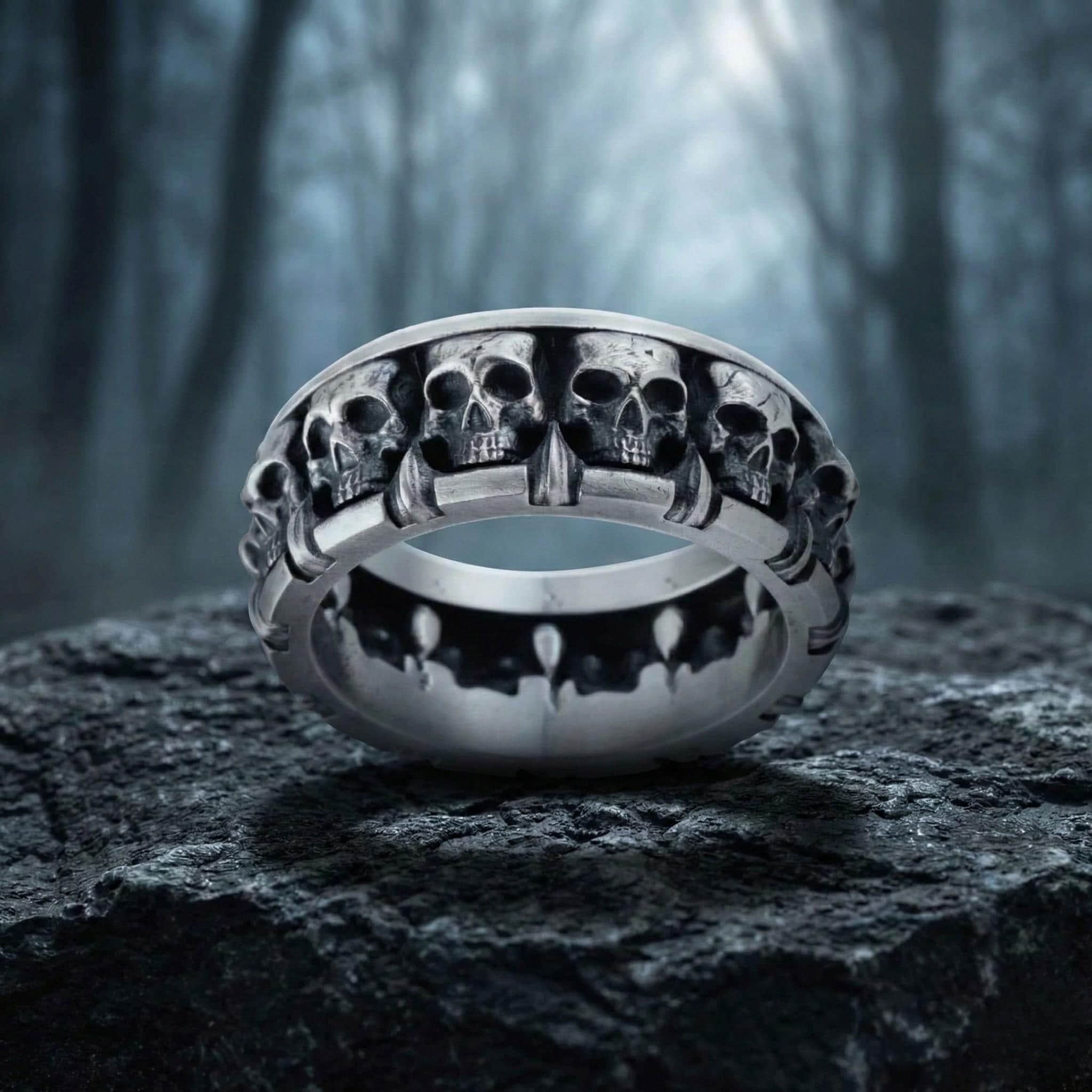 A silver ring with a row of skull designs on it, set against a dark, moody background.