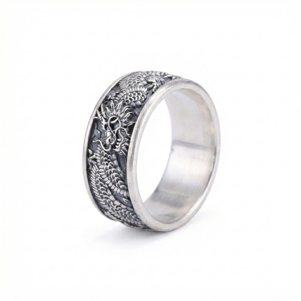 A silver ring with an intricate dragon design on the band.