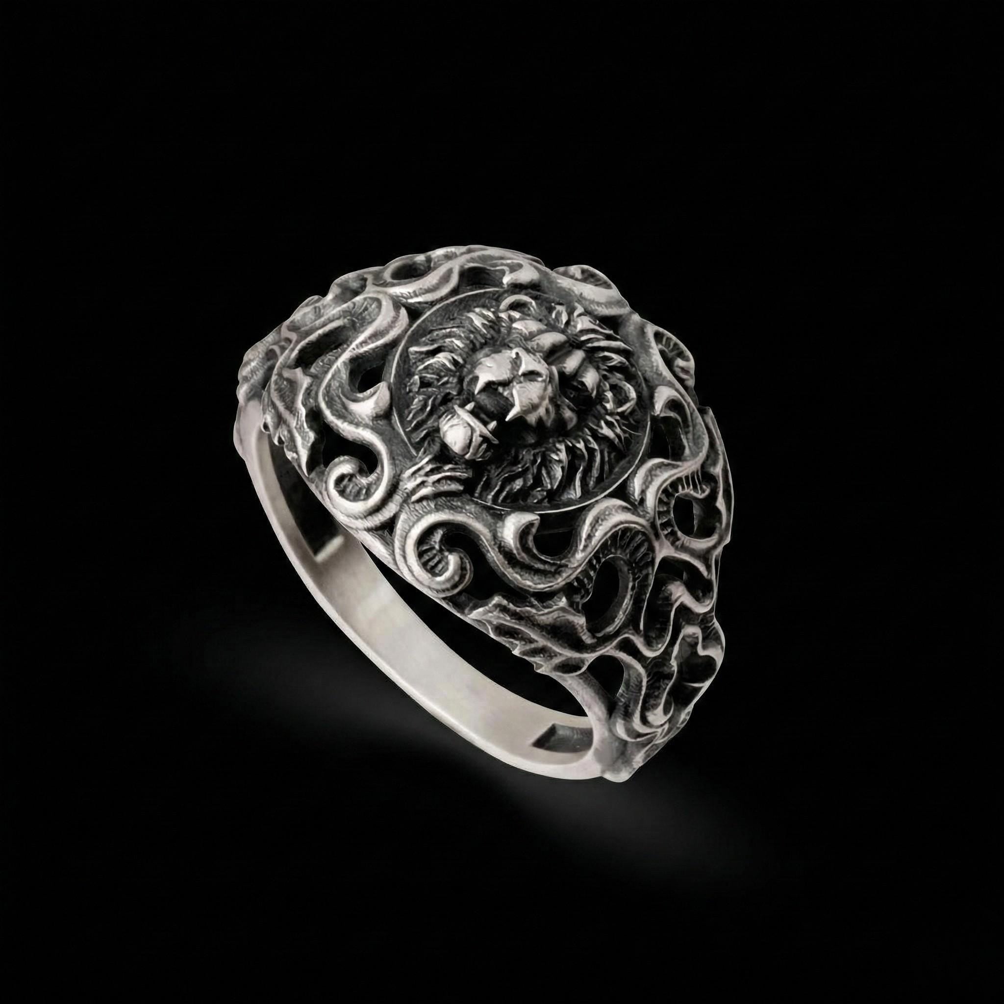 A silver ring with an intricate design featuring a lion's head at the center.