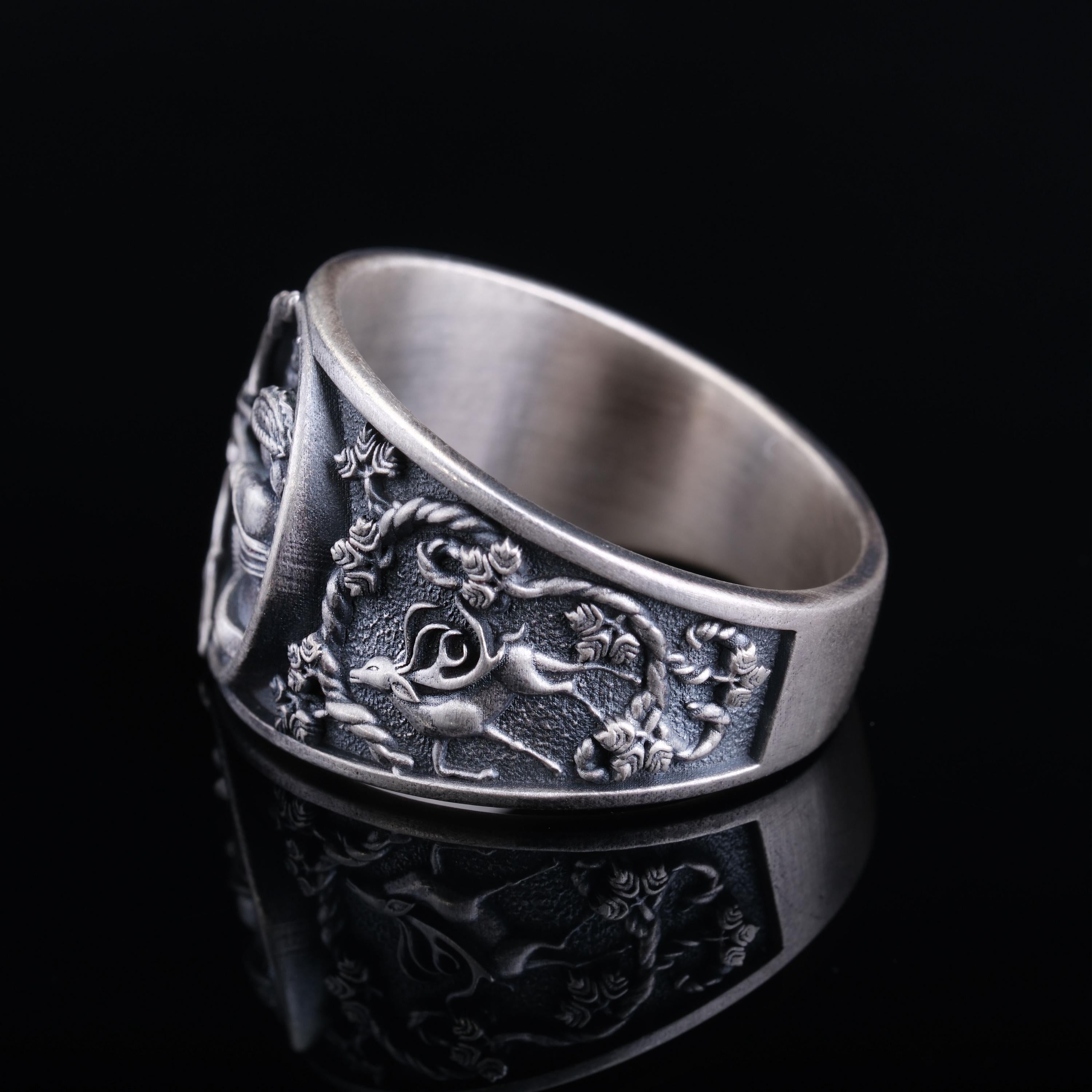 A silver ring with an intricate, embossed design featuring a dragon, a symbol often associated with Chinese culture.