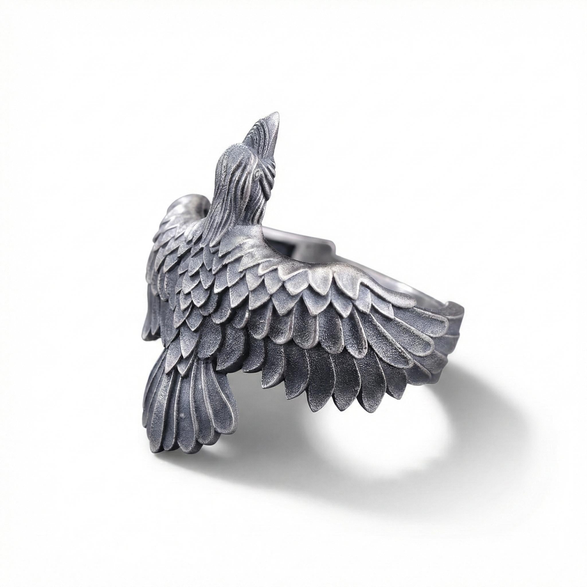 A silver-colored metal bird sculpture with detailed feathers and a pointed beak.