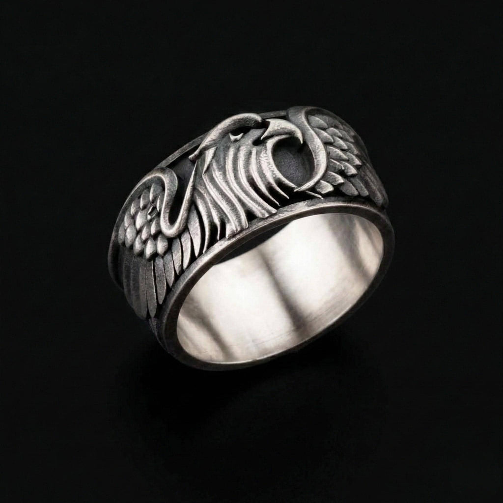 A silver ring with an intricate design featuring a winged eagle or phoenix-like creature.