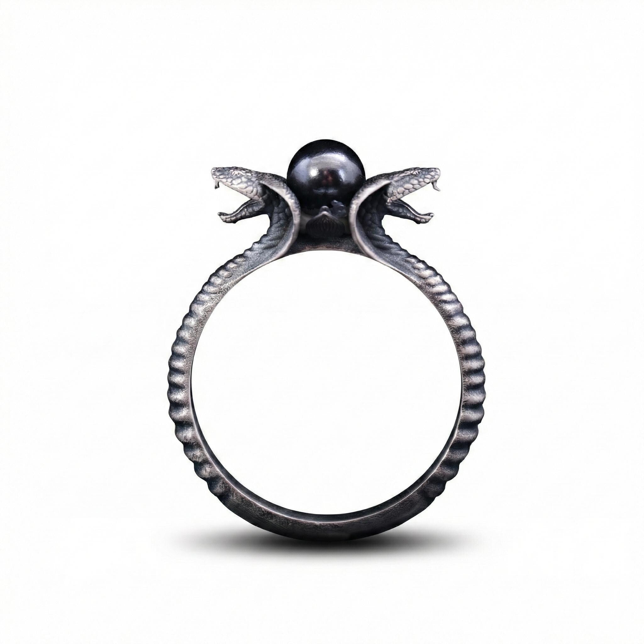 A ring with a snake design on top, featuring two snakes with their heads open, and a pearl at the center.