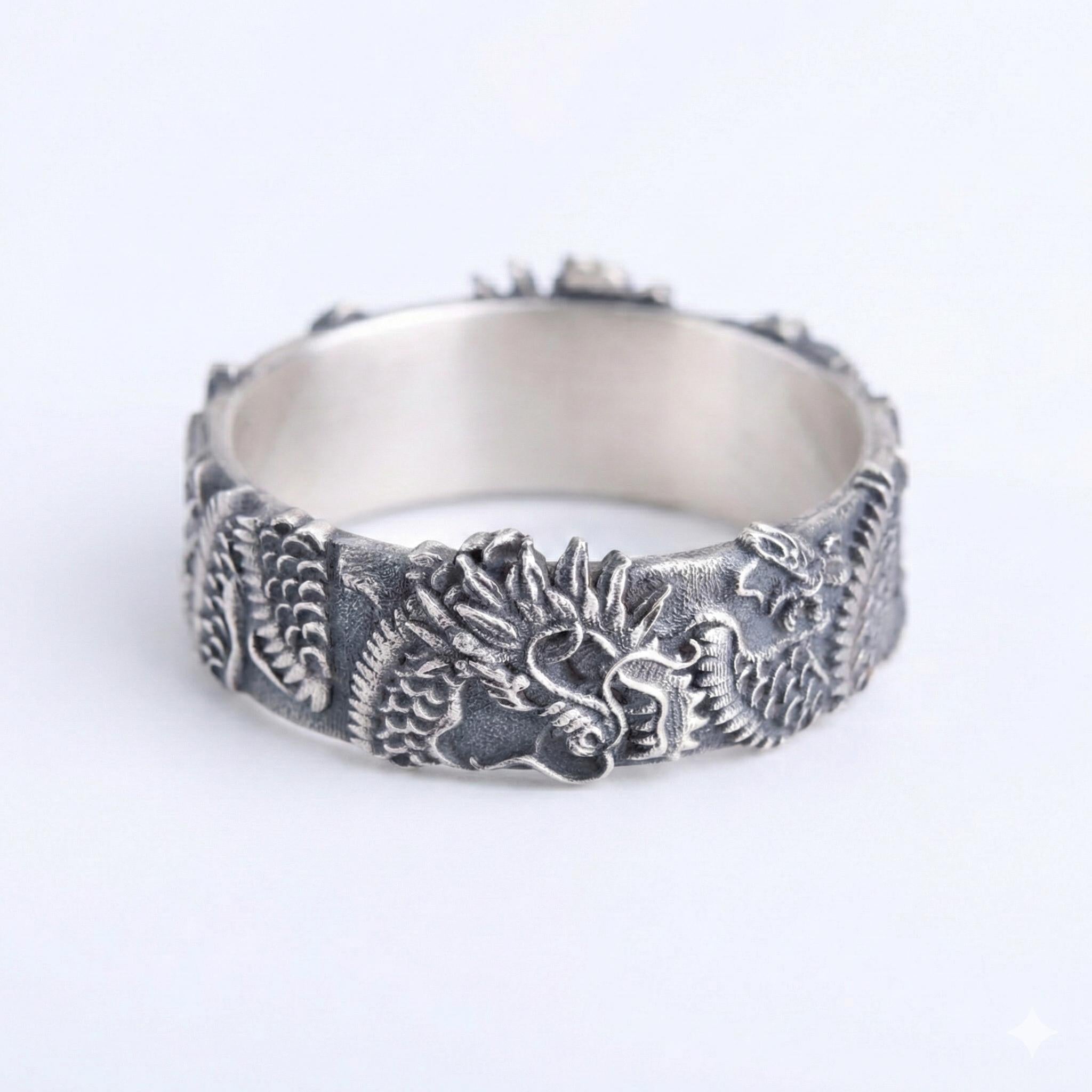 A silver ring with an intricate dragon design on the band.