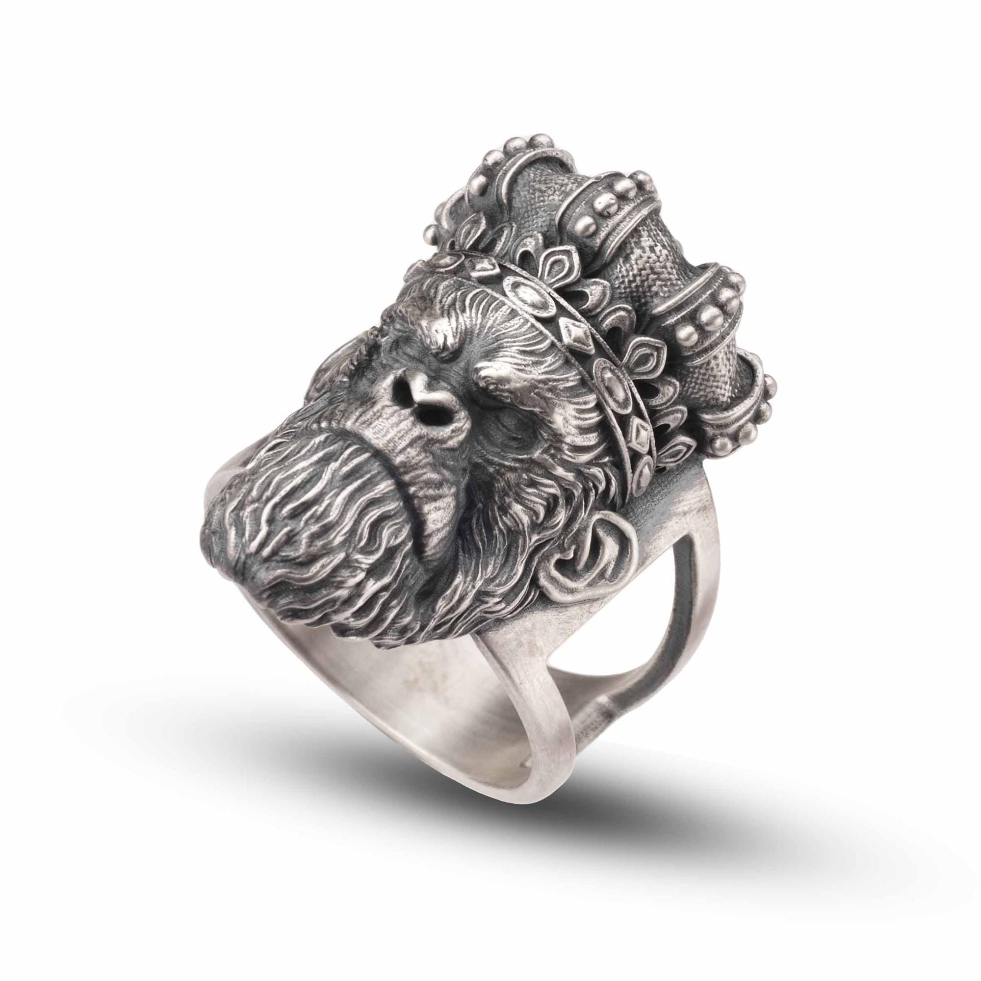 A silver ring featuring a detailed, engraved monkey head with a crown-like design.