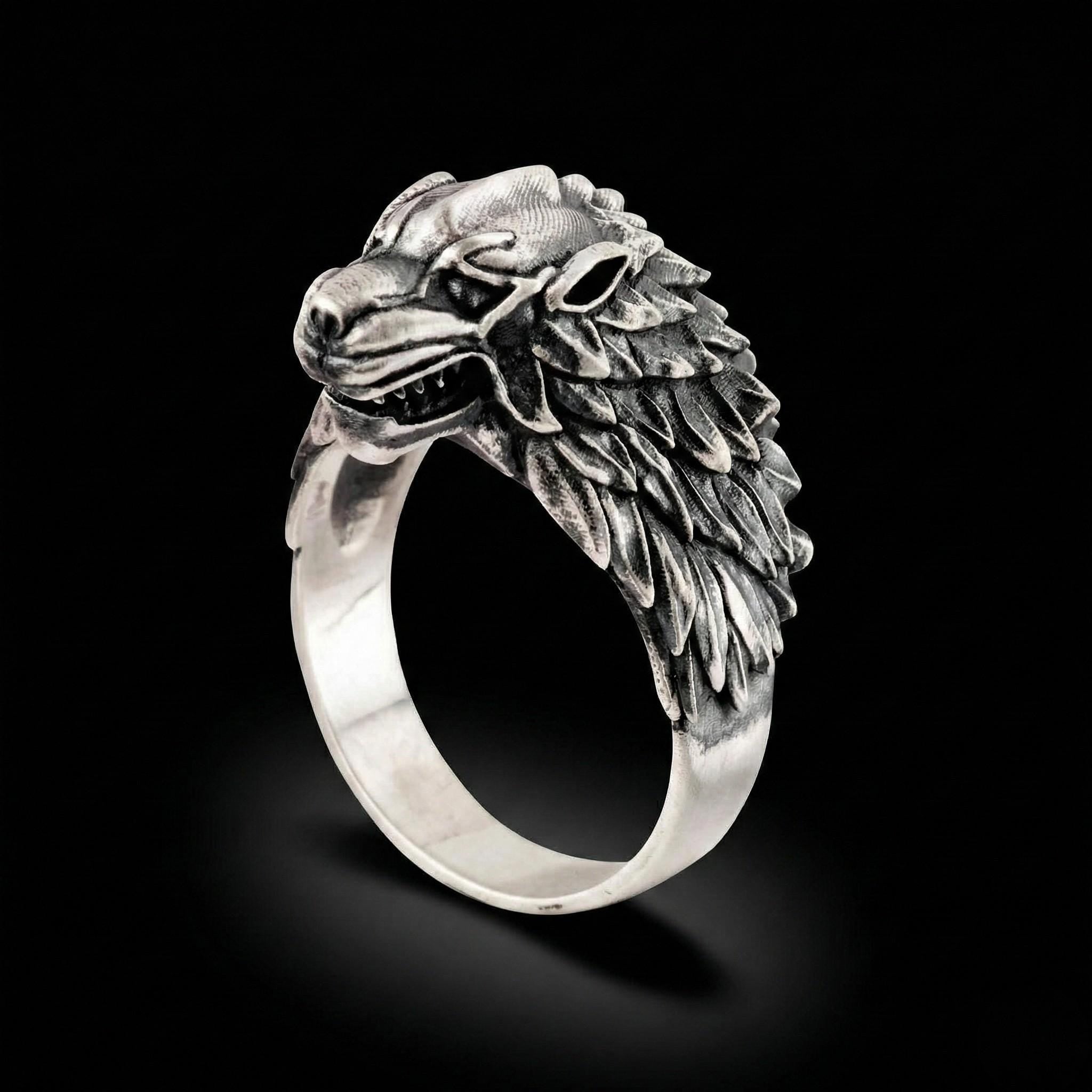 A silver ring with a detailed, sculpted wolf head design.