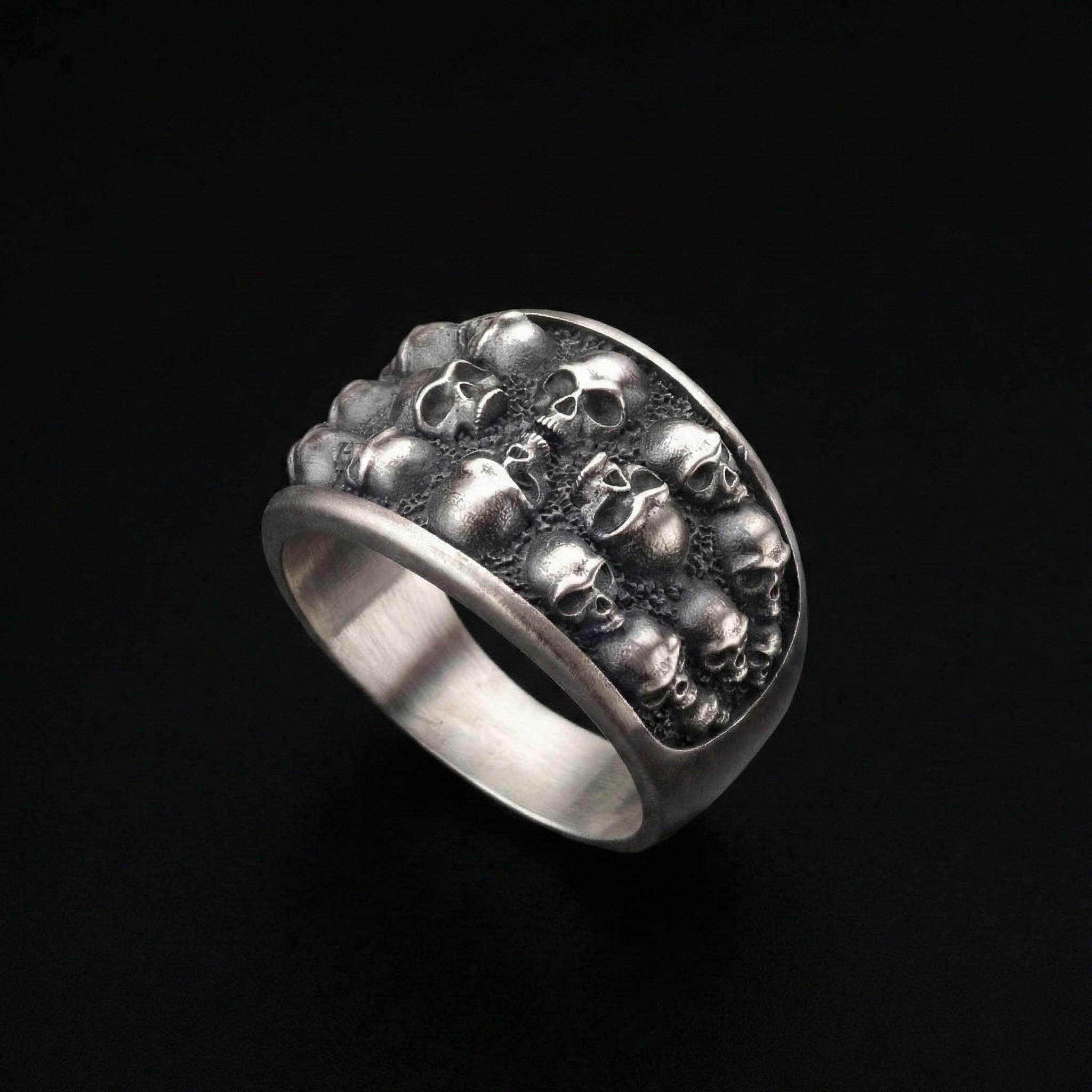 A silver ring with a unique design featuring a large number of skulls arranged in a circular pattern.