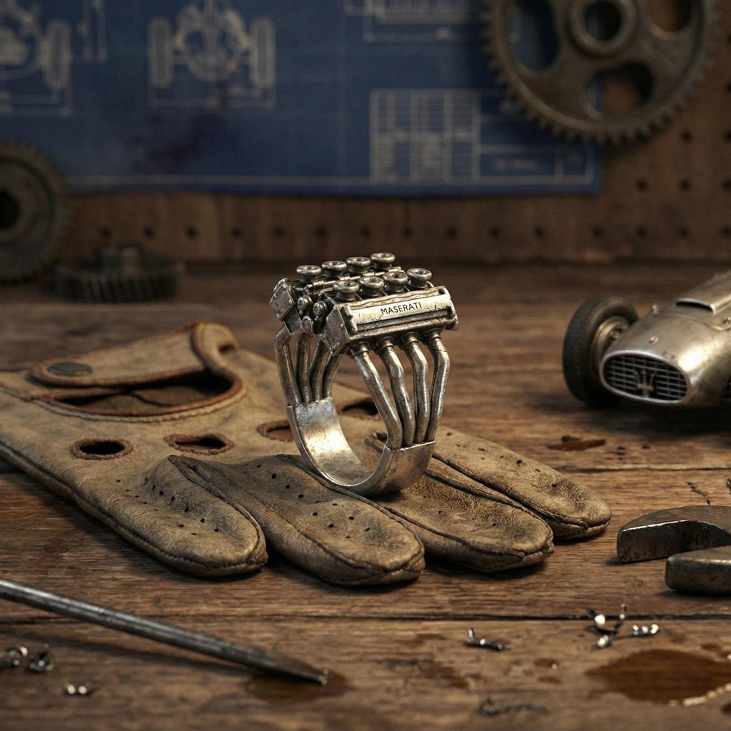 a collection of tools and objects, including a ring, a wrench, a car model, and a pair of gloves, all arranged on a wooden surface.