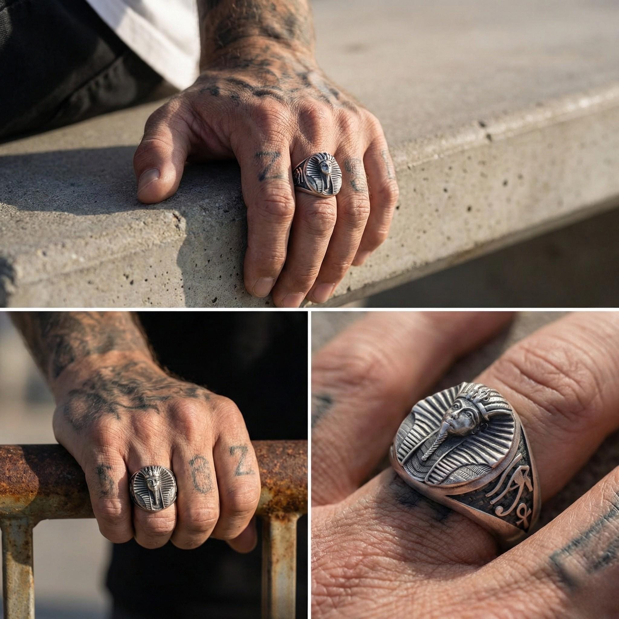 A person's hand wearing a large, ornate ring with a pharaoh-like design, resting on a railing.