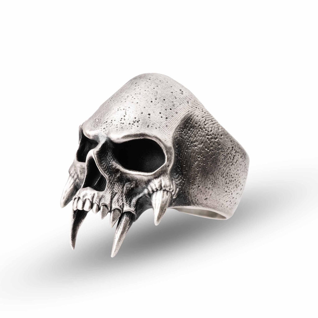 A silver ring in the shape of a skull with sharp teeth protruding from the sides.