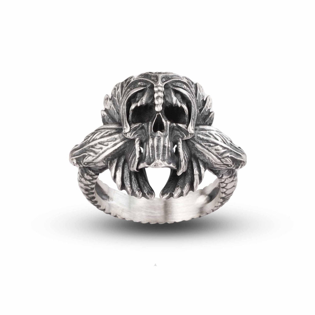 A silver ring with an intricate design featuring a skull and two snakes.