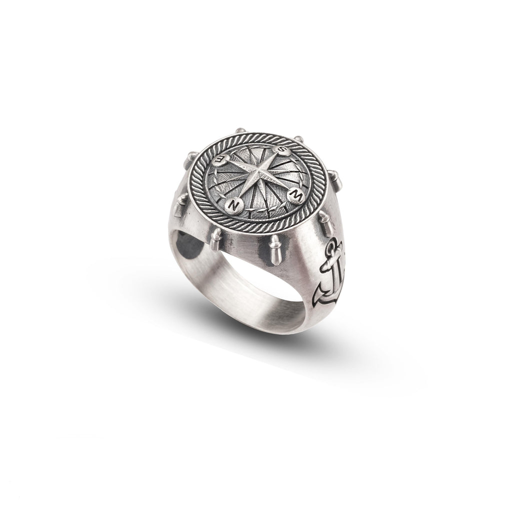 A silver ring with a compass design on the front.