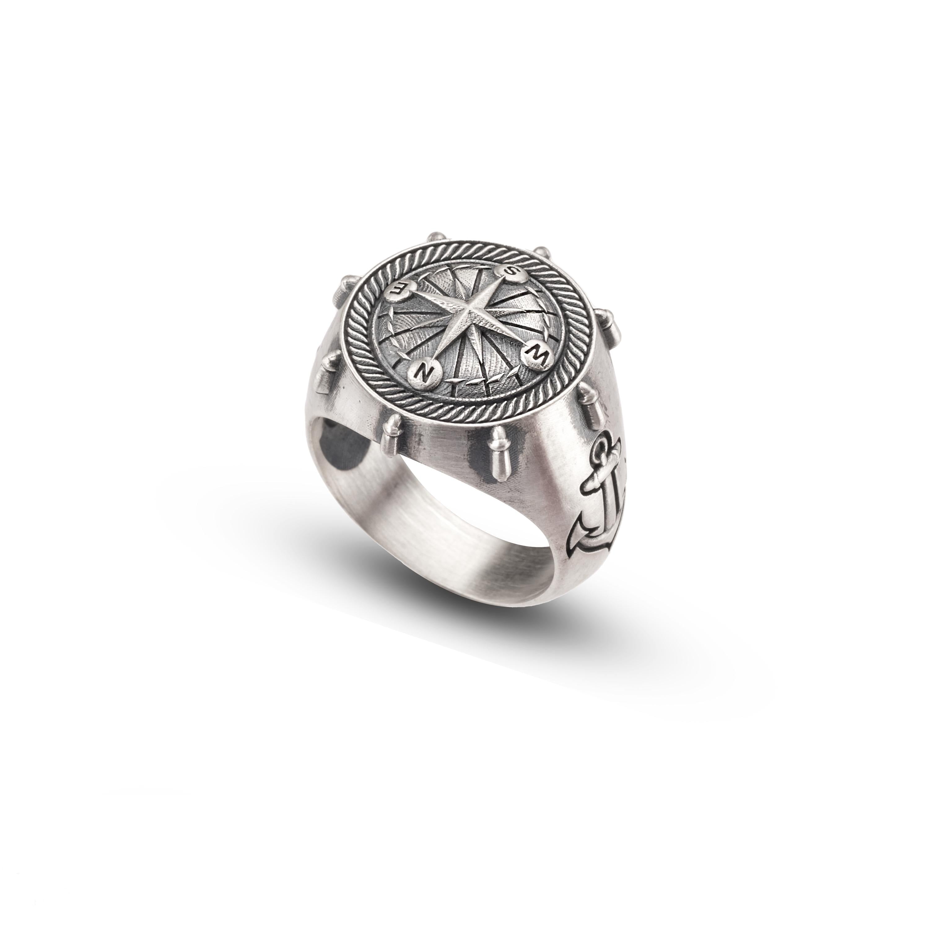 A silver ring with a compass design on the front.