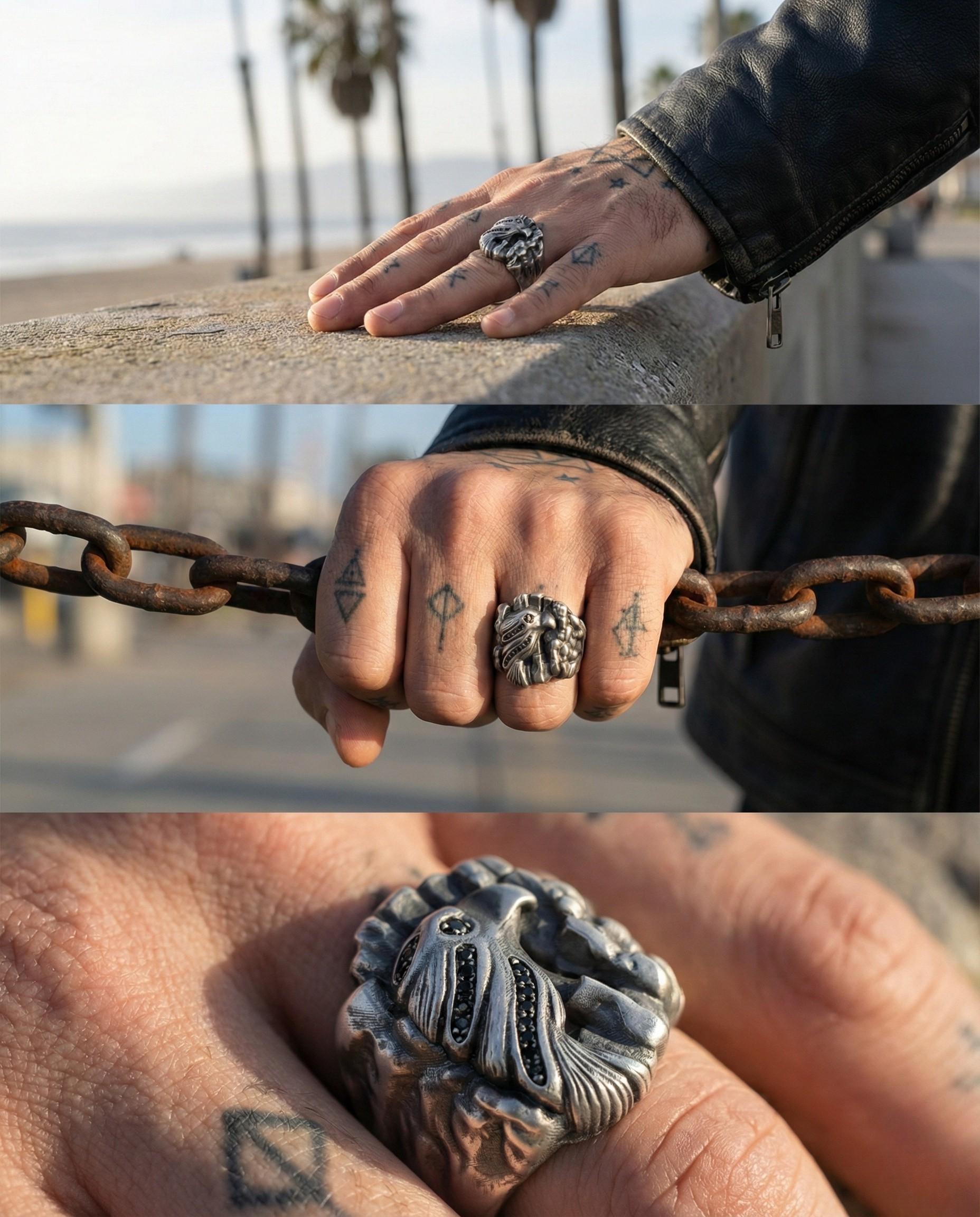 A person's hand wearing multiple rings, including a large ring with a lion design, and a ring with a floral design. The person is holding a chain with a rusted appearance.