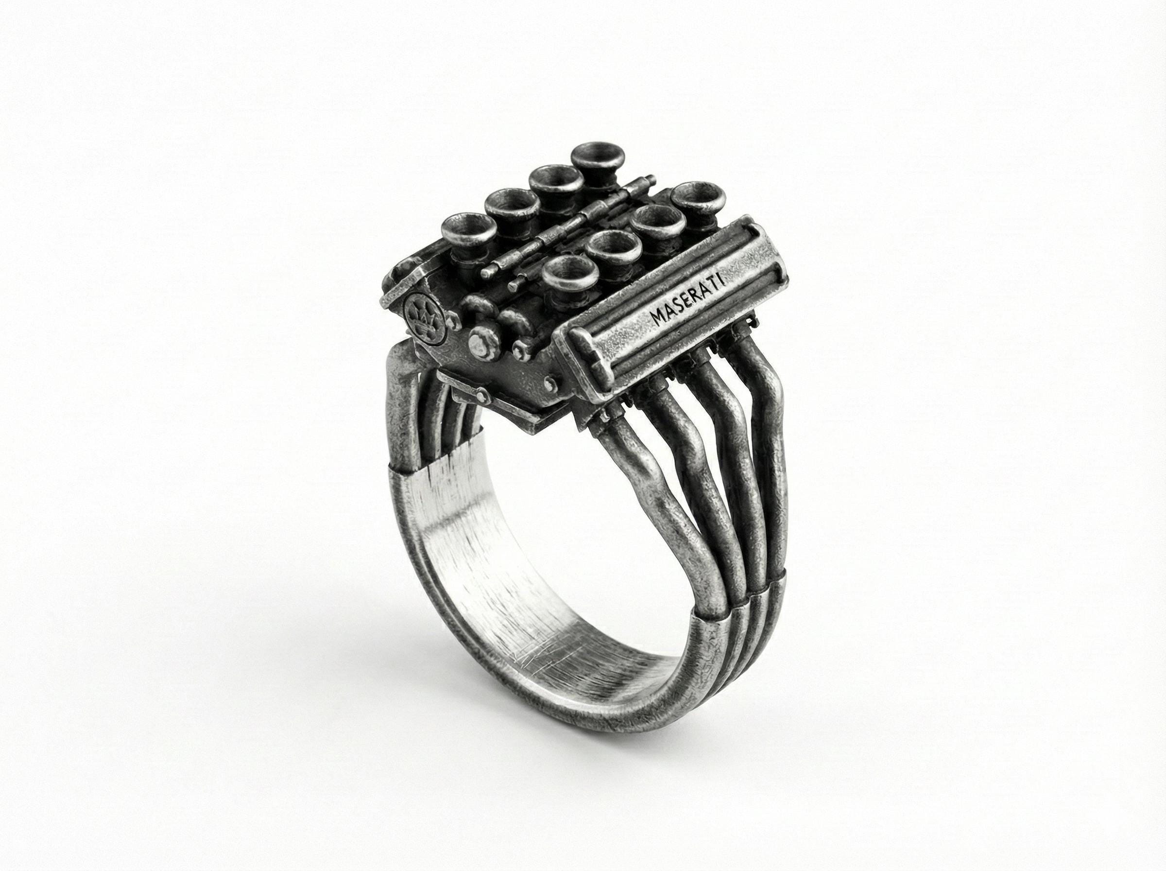A ring with a metal engine design, featuring multiple pipes and components.