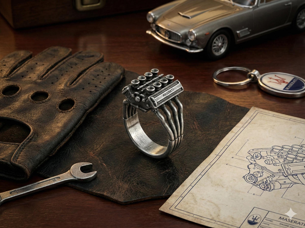 a ring with a car engine design, a pair of leather gloves, a wrench, a keychain, and a technical drawing of a car engine.