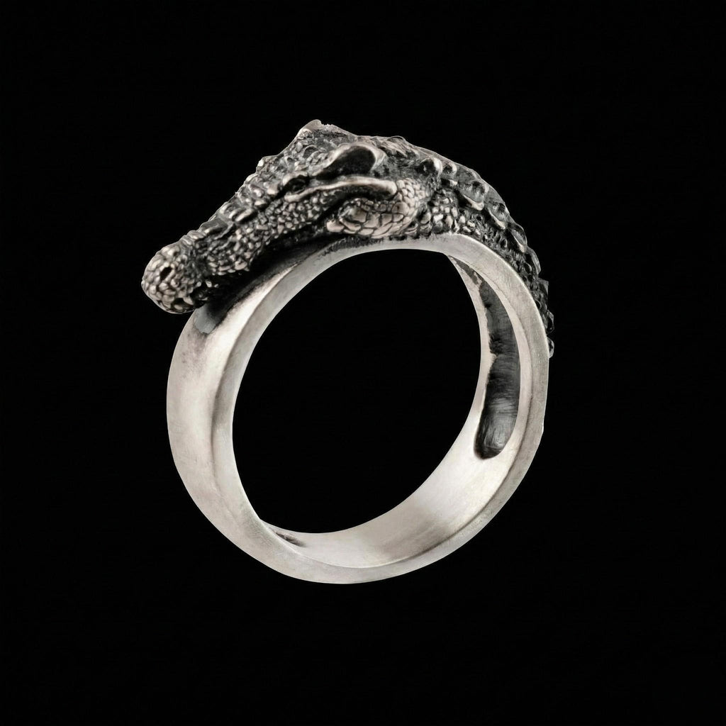 A silver ring with a crocodile head design on it.