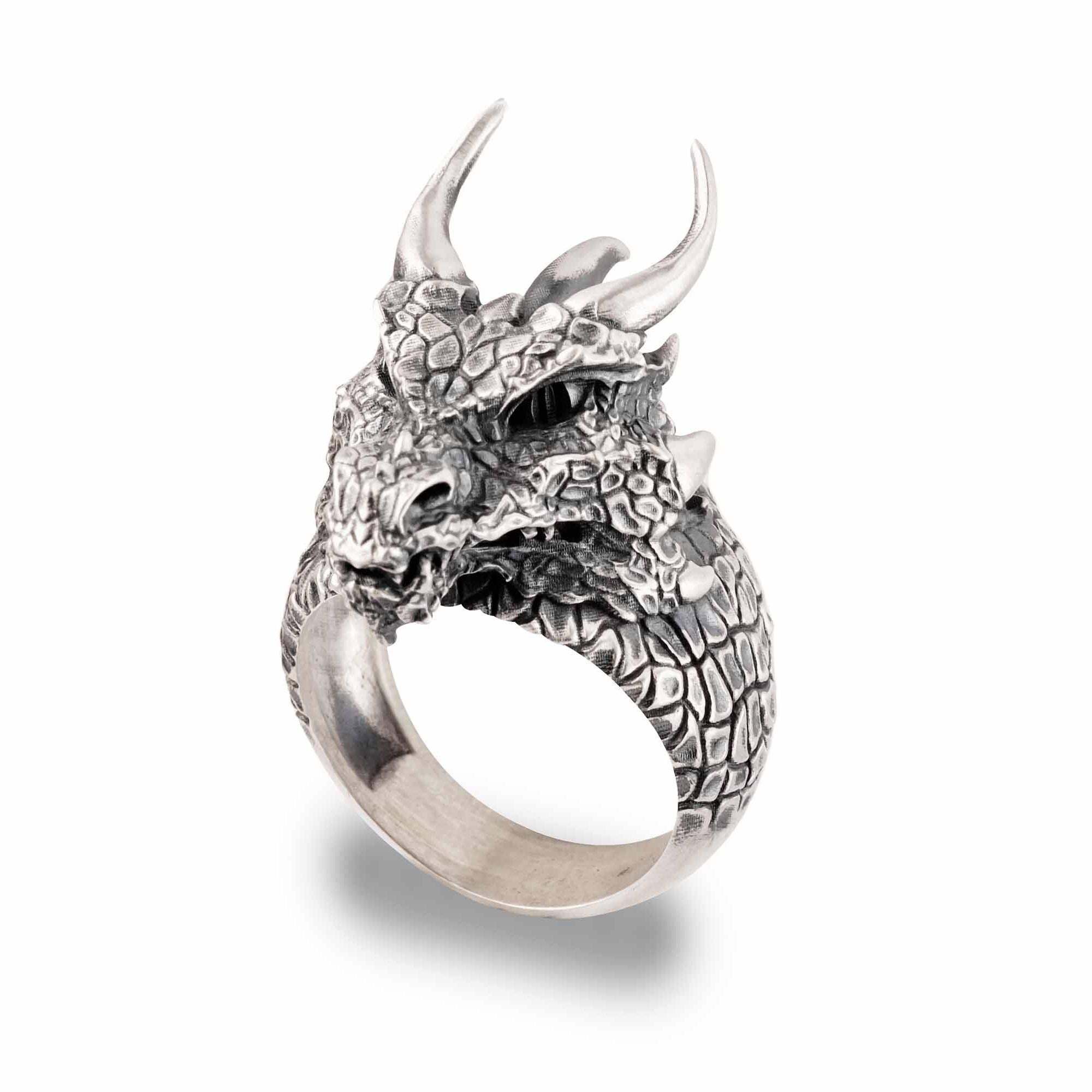 A silver ring in the shape of a fierce dragon's head with sharp horns and a textured body.